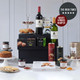 The Classical: A display of gourmet food and beverages, featuring two bottles of wine, assorted pastries, and a variety of jars and boxes with snacks. The items are arranged on a black pedestal with white plates showcasing cookies and preserves, set against a neutral background. The Classical: A display of gourmet food and beverages, featuring two bottles of wine, assorted pastries, and a variety of jars and boxes with snacks. The items are arranged on a black pedestal with white plates showcasing cookies and preserves, set against a neutral background.